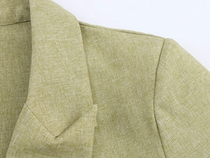 Detailed close-up showing the lapel and linen-textured fabric of the light green suit jacket