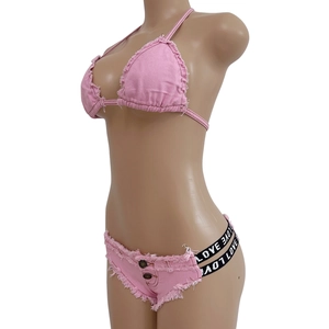 Dettaglio bikini in denim rosa con elastico LOVE e bordi sfilacciati su manichino