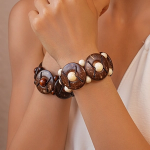 Gros plan d'un bracelet élastique en perles de noix de coco et perles crème rondes