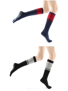 Detail view of non-slip white dots on five-finger yoga socks in navy and black
