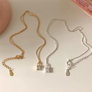 Close-up of S925 sterling silver lock pendants with square zircon in gold and silver finish