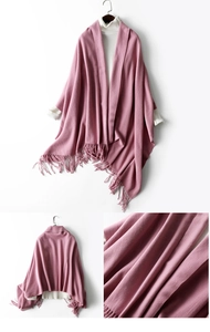 Close-up of pink knit wool shawl featuring delicate fringe edge details and soft texture