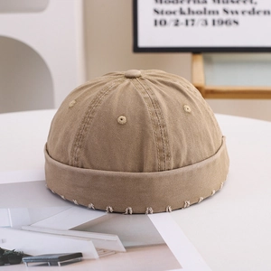 Detailed close-up of khaki docker hat showing cotton twill fabric and white stitching