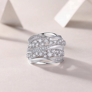 Macro shot of silver wide band ring with intertwined lines and crystal floral patterns