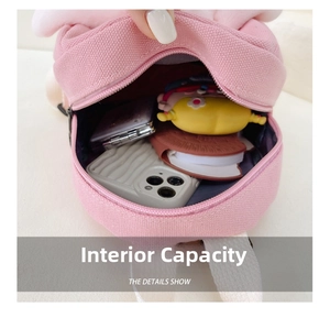 Internal view of pink canvas backpack showing capacity for phone, mirror and wallet