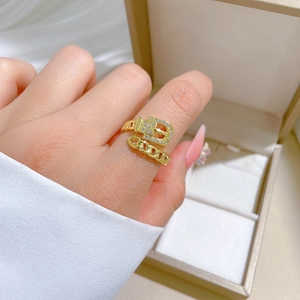 Adjustable gold chain belt ring with pavé crystals shown on a hand near a jewelry box