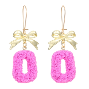 Détail de boucles d'oreilles nœud doré avec pendentifs roses aux motifs de roses 3D