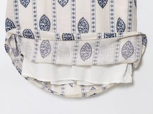 Detail of blue floral print on cotton linen dress with smooth white inner lining fabric