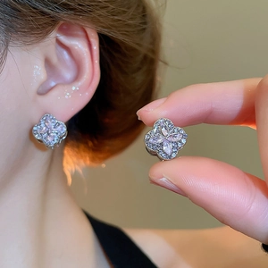 Detailed close-up of pink zircon four-leaf clover earrings with micro-pave crystals