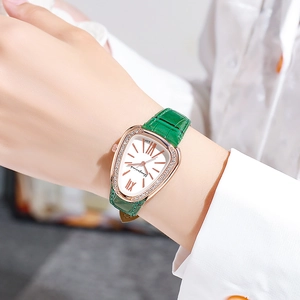 Close-up of rose gold snake-style quartz watch with green leather strap and diamond bezel