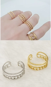 Detail of 18K gold and silver stainless steel layered rings with bead and curb chains