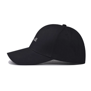 Close-up of small white script embroidery on a black washed cotton baseball cap