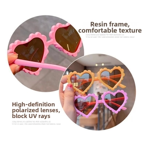 Detailed view of heart-shaped kids sunglasses with wavy resin frames and polarized lenses