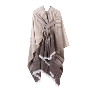 Detail of beige gradient knit shawl featuring stripe patterns and elegant fringe tassels