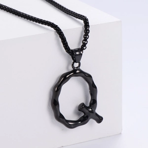 Gros plan du pendentif lettre Q 3D noir sur pierre blanche avec sa chaîne à billes