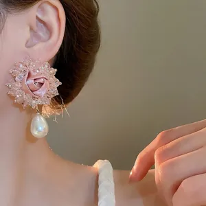 Pink satin flower earrings with sparkling crystals and a large white drop pearl