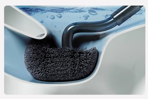 Detail of S-shaped toilet brush cleaning corners of a white ceramic toilet with blue water