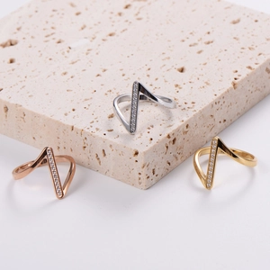 Classic V-shaped diamond geometric rings in gold, silver, and rose gold on stone display