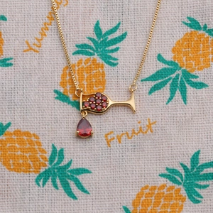 Gold wine glass necklace with red zircons and pear-shaped ruby on fruit pattern cloth