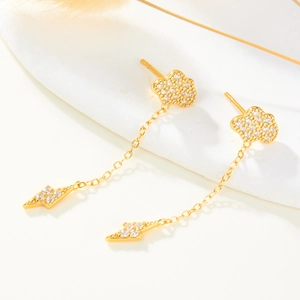 Detailed view of gold cloud and lightning dangle earrings with micro-set zircon stones