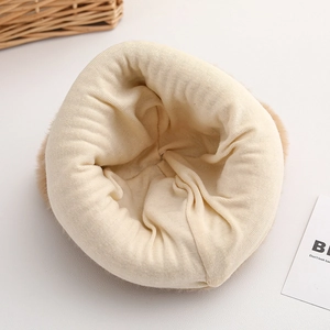 Detailed inner view of warm beige knitted baby hat with thick faux fur lining