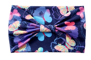 Detail of navy blue wide headband featuring colorful floral patterns and knot design