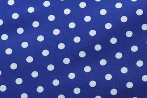 Close-up of vintage blue dress fabric with classic white polka dot pattern detail