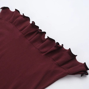 Detalle de vestido de punto granate con ribete negro en contraste y dobladillo volante
