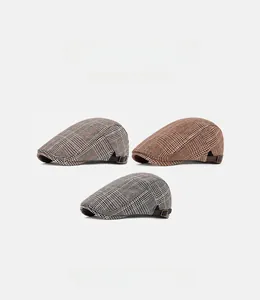 Detailed view of three checkered ivy caps in grey, brown and blue with metal buckles