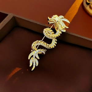 Detail of gold-plated dragon brooch with pave-set rhinestones on a jewelry box