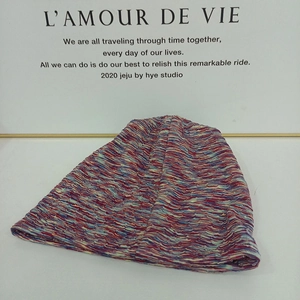 Detail of red and blue space-dye knit texture on a cozy autumn winter slouchy beanie hat