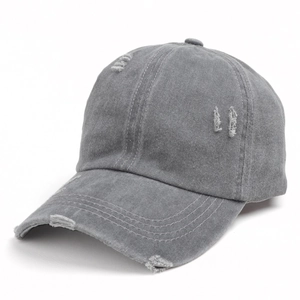 Detailed macro view of gray washed cotton baseball cap featuring vintage distressed holes
