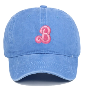 Close-up of pink embroidered letter B on light blue washed cotton baseball cap texture