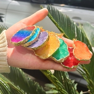 Detailed close-up of colorful irregular natural stone keychains with golden edges