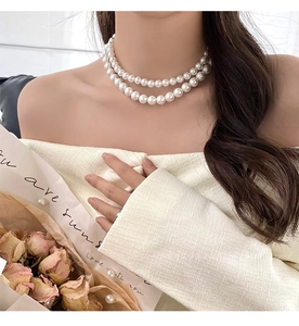 Gros plan sur l'élégant collier double épaisseur en perles blanches porté par un mannequin