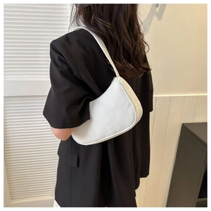 Close-up of a white corduroy crescent shoulder bag styled with a black blazer