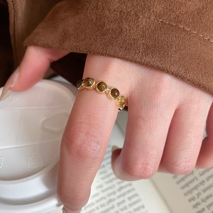 Close-up of gold plated ring with tiger eye stones against a vintage autumn backdrop