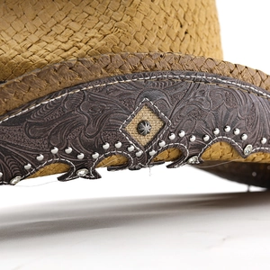 Macro view of woven cowboy hat with embossed leather band, metal studs, and crystal accents