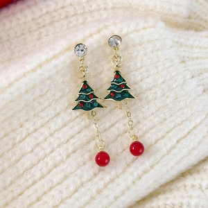 Detaillierte Makroansicht der grünen Emaille-Weihnachtsbaum-Ohrringe mit roten Perlen