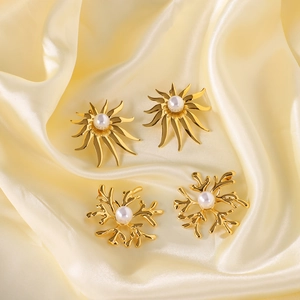 Gold-plated coral and sunburst earrings with pearls on elegant silk background