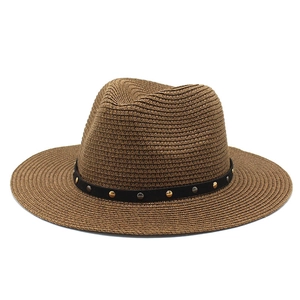 Brown straw panama hat with black studded band and flat brim for outdoor sun protection