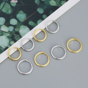 Flat lay of minimalist gold and silver S925 sterling silver hoop earrings set