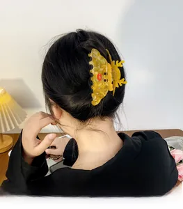 Yellow acrylic Christmas hair claw clip with reindeer antlers and rhinestones on a bun
