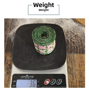Detail view of 36g roll of pink plaid ribbon with green floral pattern for gift wrapping