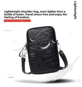 Détail d'un petit sac de téléphone léger en cuir noir avec motifs floraux de camélia