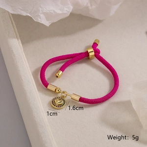 Detail of rose red braided rope bracelet with 1cm gold heart pendant and zircon