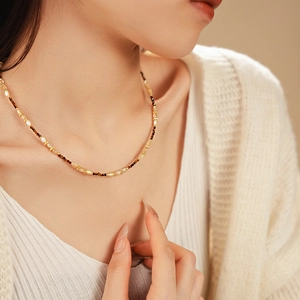 Détail du collier de perles en nacre fleurie au cou, bijoux vintage français chic