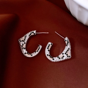 Detailed view of leopard-print C-shape earrings with black and white zircons