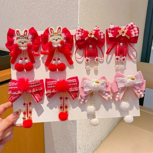 Detail of red and white New Year hair clips with tassels, ribbons and pearls