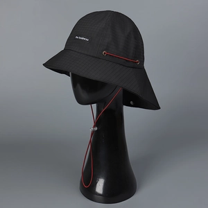 Detail of waterproof checkered nylon sun hat with red windproof drawstring and logo